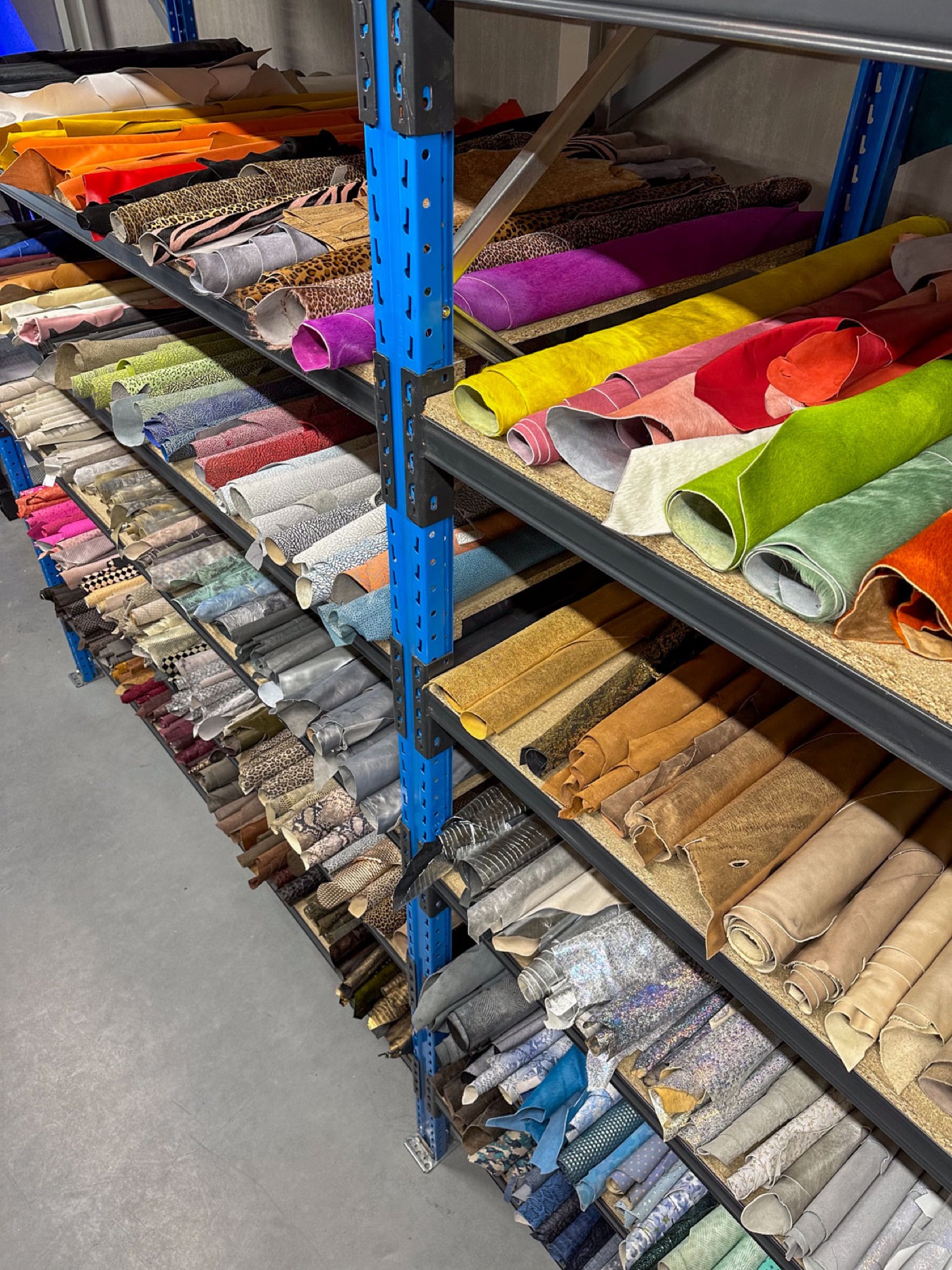 Rekken vol gekleurd leer in de studio van De Leergroothandel